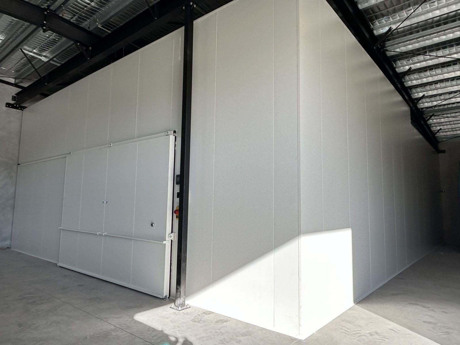 Câmara fria instalada em galpão com porta de correr